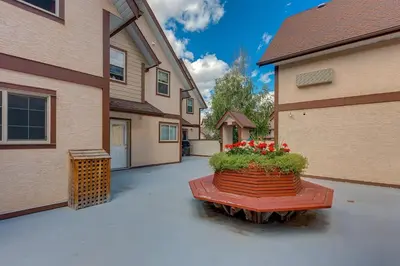 a patio with a planter with red flowers in it at Stunning Mountain View Cozy Studio for Small Grp in Canmore