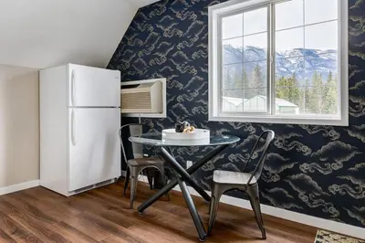 a kitchen with a table and a refrigerator and a window at The Perfect Getaway for Exploring Canmore and Banff) in Canmore
