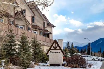a sign in front of a house in the snow at Charming and Stylish renovated Condo near Banff in Canmore