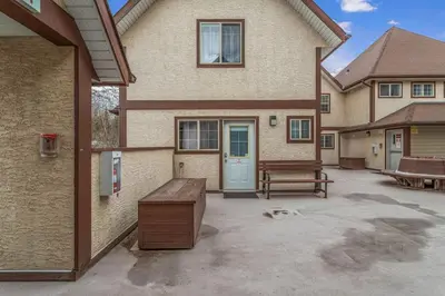 a house with a bench in front of it at Charming and Stylish renovated Condo near Banff in Canmore