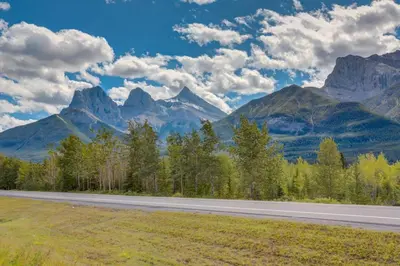an empty road with mountains in the background at Cozy Tropical Vibe Haven in Canmore near Banff in Canmore