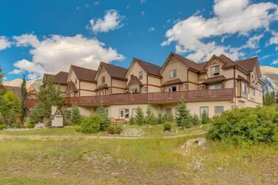 a large house in the mountains with a yard at Cozy Tropical Vibe Haven in Canmore near Banff in Canmore