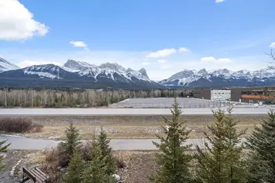 a view of a snowy mountain range with a road at Cozy Tropical Vibe Haven in Canmore near Banff in Canmore