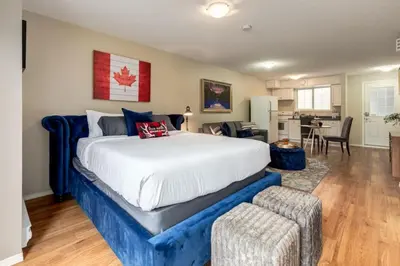 a bedroom with a large bed and a living room at Cozy Condo in the Heart of Canmore in Canmore
