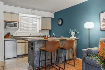 a kitchen with a wooden island in a living room at Stylish Getaway in the Heart of Canmore near Banff in Canmore