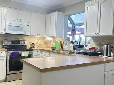 a kitchen with white cabinets and a counter top at Luxury & Spacious three bedrooms House Near Coquitlam Town Centre in Coquitlam
