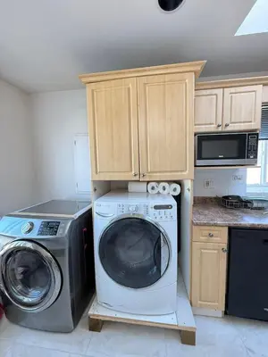 a kitchen with a washing machine and a microwave at Cozy Private Room near Langara College Skytrain Station in Vancouver