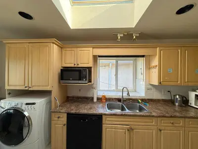 a kitchen with a sink and a microwave at Cozy Private Room near Langara College Skytrain Station in Vancouver