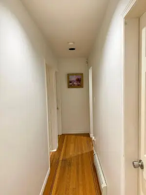 an empty hallway with white walls and wood floors at Cozy Private Room near Langara College Skytrain Station in Vancouver