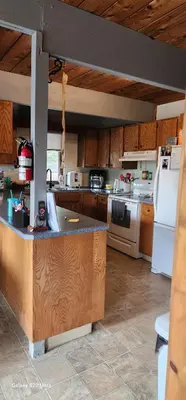 a kitchen with wooden cabinets and a white refrigerator at Brown Family Farm in Grand Forks