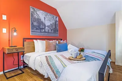 two beds in a room with orange walls at Traveler Friendly Canmore Condo Close to Banff in Canmore