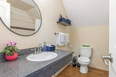 a bathroom with a sink and a toilet and a mirror at Traveler Friendly Canmore Condo Close to Banff in Canmore