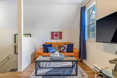 a living room with a couch and a table at Traveler Friendly Canmore Condo Close to Banff in Canmore