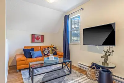 a living room with a couch and a tv at Traveler Friendly Canmore Condo Close to Banff in Canmore