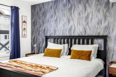 a bedroom with a large bed with a blue wall at Mesmerizing 2BR Retreat Made For You in Canmore