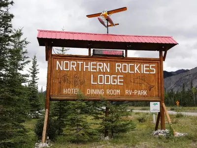 a sign for a northern rocks lodge with a propeller on top at Northern Rockies Lodge in Muncho Lake