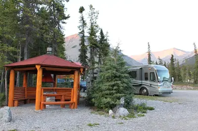 a wooden gazebo with a tent and a rv at Northern Rockies Lodge in Muncho Lake