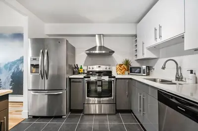 a kitchen with stainless steel appliances and a sink at Peaceful DT Condo, Saddledome, HeatedParking in Calgary
