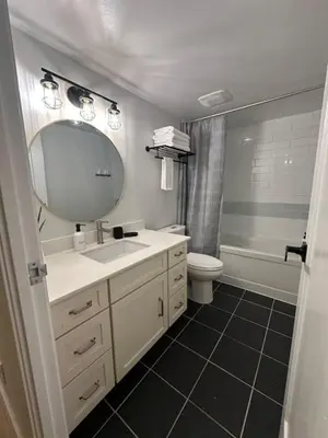 a bathroom with a sink and a mirror and a toilet at Peaceful DT Condo, Saddledome, HeatedParking in Calgary