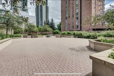 a courtyard in a city with benches and buildings at Peaceful DT Condo, Saddledome, HeatedParking in Calgary