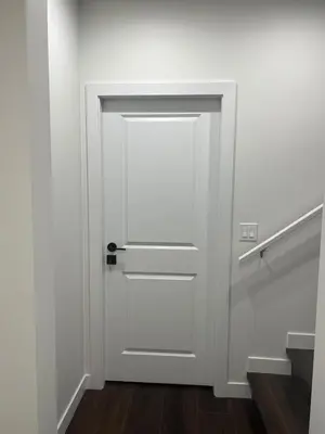 a white door in a white room with wooden floors at Kizito in Edmonton