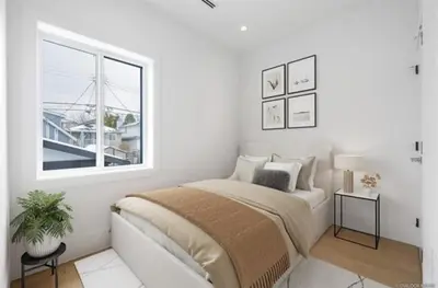 a white bedroom with a bed and a window at Luxury & brand-new Cozy duplex in South Vancouver in Vancouver