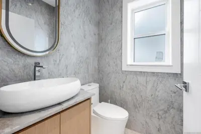 a bathroom with a sink and a mirror and a toilet at Luxury & brand-new Cozy duplex in South Vancouver in Vancouver