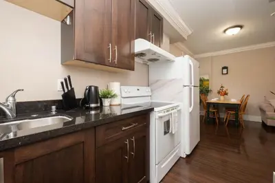 a kitchen with a sink and a white refrigerator at Cozy 3 BR Suite Ideal for Families and Groups in Vancouver