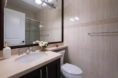 a bathroom with a sink and a toilet and a mirror at Cozy 3 BR Suite Ideal for Families and Groups in Vancouver