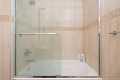 a shower with a glass door in a bathroom at Cozy 3 BR Suite Ideal for Families and Groups in Vancouver