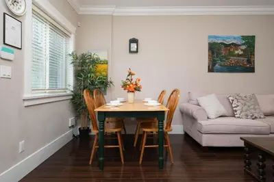 a living room with a table and chairs and a couch at Cozy 3 BR Suite Ideal for Families and Groups in Vancouver