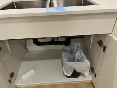 a trash can under a sink with a trash bag under it at cozy basement suite with 1-bed, wi-fi & Neflix in Edmonton