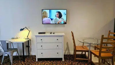 a living room with a table and a tv on the wall at Cloud 9 Inn in Whitecourt