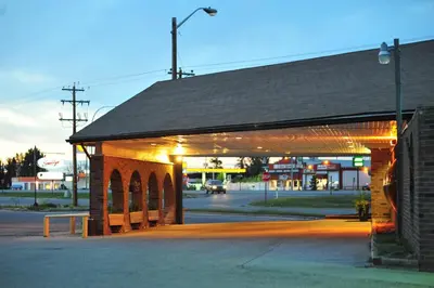 a red brick building with lights on a street at Cloud 9 Inn in Whitecourt