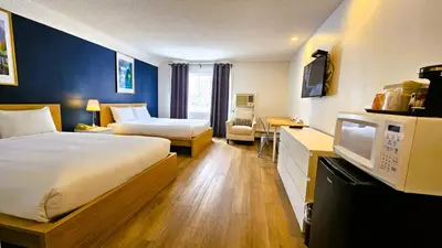 a hotel room with two beds and a tv at Cloud 9 Inn in Whitecourt