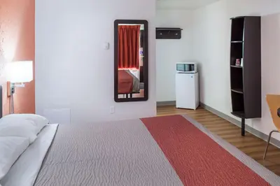 a bedroom with a bed and a mirror in it at Motel 6-Fort St. John, BC in Fort Saint John