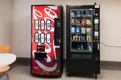 two soda vending machines are next to each other at Motel 6-Fort St. John, BC in Fort Saint John