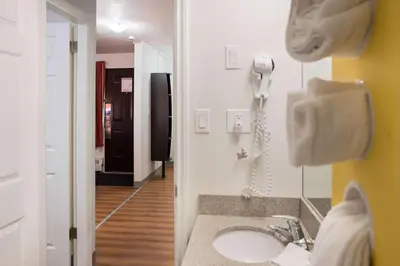 a bathroom with a sink and a phone on a wall at Motel 6-Fort St. John, BC in Fort Saint John