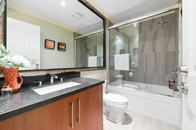 a bathroom with a sink and a toilet and a shower at Luxury 1200 squft 2BR Shaughnessy Suite Near YVR & DT in Vancouver