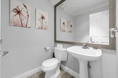 a bathroom with a toilet and a sink and a mirror at Luxury 1200 squft 2BR Shaughnessy Suite Near YVR & DT in Vancouver