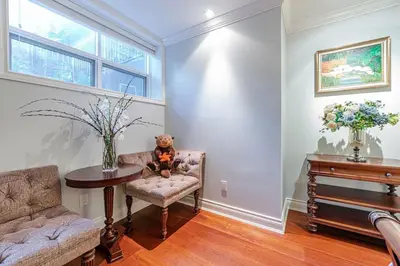 a teddy bear sitting in a chair in a living room at Luxury 1200 squft 2BR Shaughnessy Suite Near YVR & DT in Vancouver