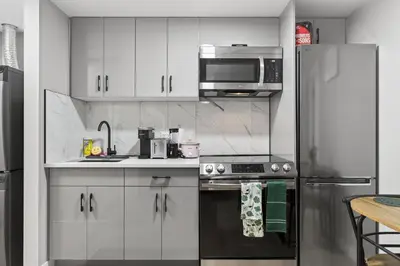 a kitchen with white cabinets and a stainless steel refrigerator at Guest Suite in Edmonton, King bed and parking in Edmonton