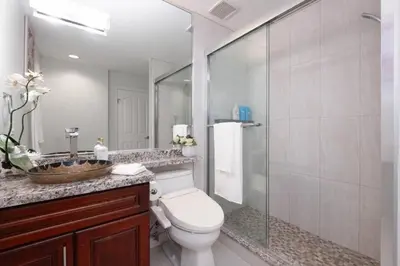 a bathroom with a toilet and a glass shower at Comfort Spacious 2-BR Suite in Arbutus in Vancouver