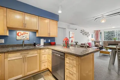 a kitchen with wooden cabinets and a counter top at 1BR + Sofa Bed | Greystone Lodge | Ski in / Ski out | Pool & Hot Tub | Epic Locations in Whistler