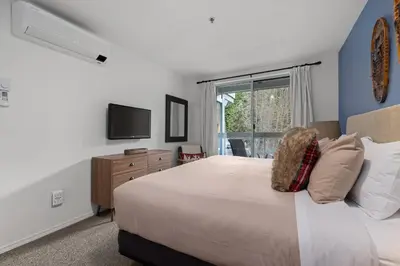a bedroom with a large bed and a television at 1BR + Sofa Bed | Greystone Lodge | Ski in / Ski out | Pool & Hot Tub | Epic Locations in Whistler