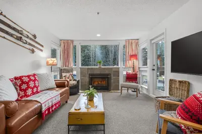 a living room with a couch and a fireplace at 1BR + Sofa Bed | Greystone Lodge | Ski in / Ski out | Pool & Hot Tub | Epic Locations in Whistler