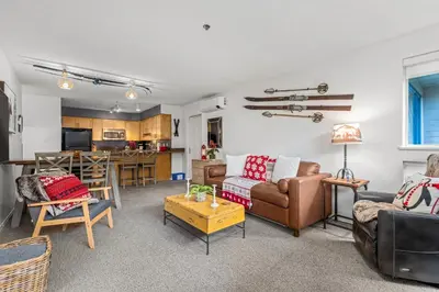 a living room filled with furniture and a kitchen at 2BR + Sofa Bed | Greystone Lodge | Ski in / Ski out | Split home living | Pool & Hot Tub in Whistler