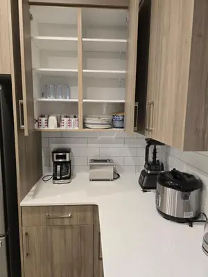 a kitchen with a white counter top with a appliance at Cozy Comfort Homestaed-Near Airport in Calgary