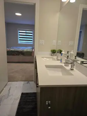 a bathroom with two sinks and a large mirror at Cozy Comfort Homestaed-Near Airport in Calgary