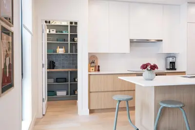 a kitchen with white cabinets and blue stools at Revel and Rest by Revelstoke Vacations in Revelstoke